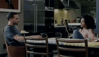 a man sits at a table with a woman sitting next to him