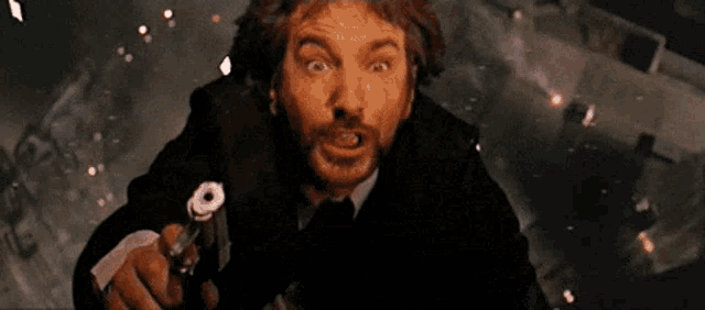 a man in a suit and tie is jumping in the air with fireworks in the background