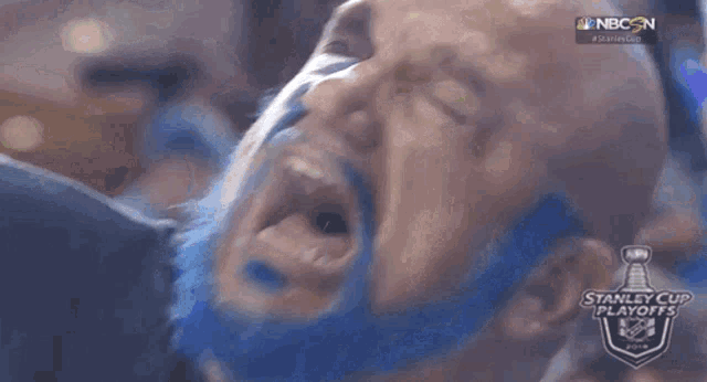 a bald man with a blue beard is screaming in a stanley cup playoffs game