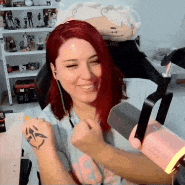 a woman with red hair is sitting in front of a microphone and a stuffed animal that says lab