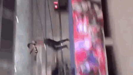 a person is flying through the air in front of a large screen in a building .