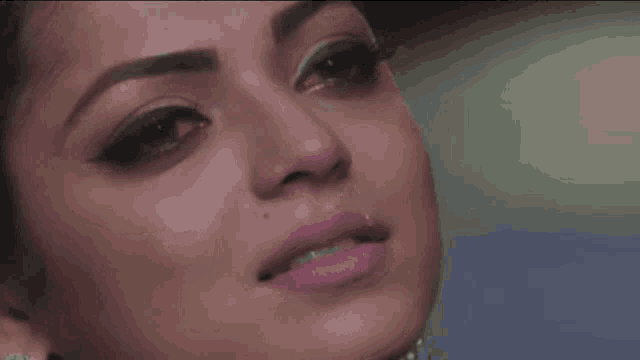 a close up of a woman 's face with pink lipstick on