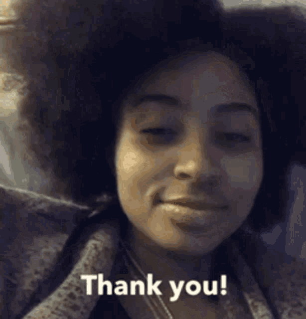 a woman with an afro is smiling and says thank you