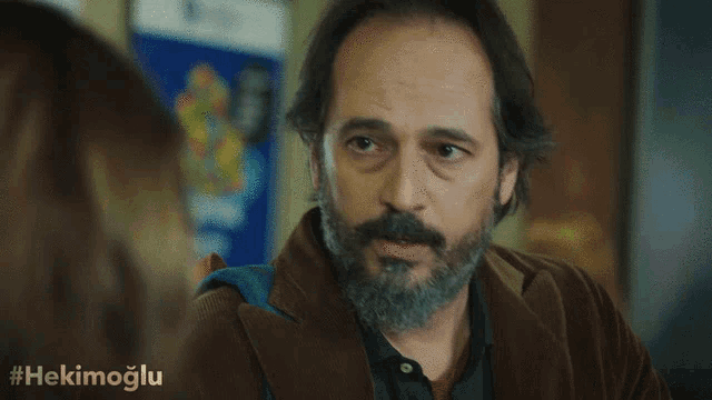 a man with a beard has the hashtag #hekimoglu written on the bottom