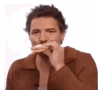 a man in a brown jacket is holding a piece of bread in his mouth .