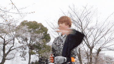 a man in a black and white shirt is holding a sword