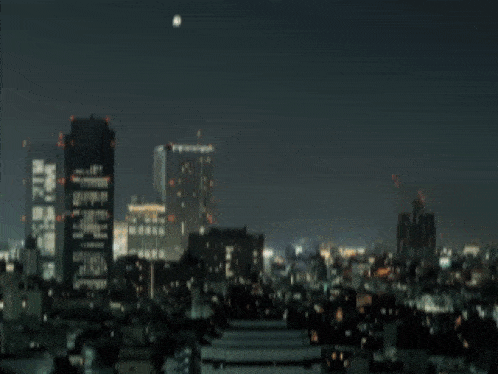 a city at night with a large explosion coming out of the sky
