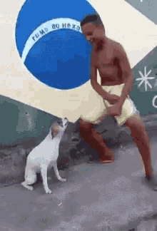 a man is standing next to a dog in front of a brazilian flag .