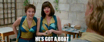 two women are standing next to each other in a restaurant and one of them says he 's got a boat