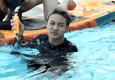 a man in a wet suit is holding a banana in a pool