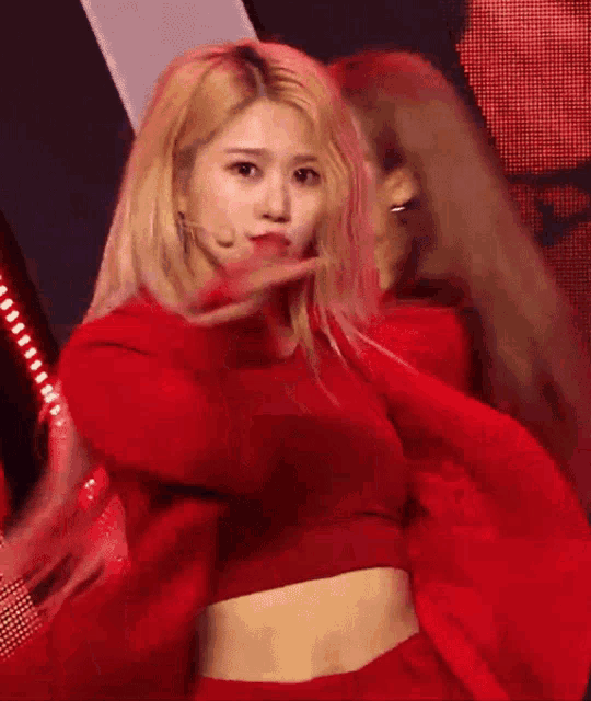 a blonde woman in a red crop top is dancing