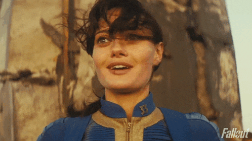 a woman is wearing a blue jacket with the letter t on it