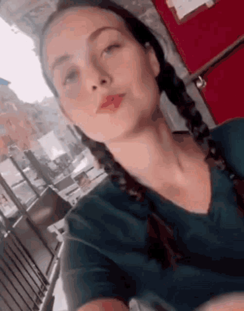 a woman with pigtails is taking a selfie with her phone .