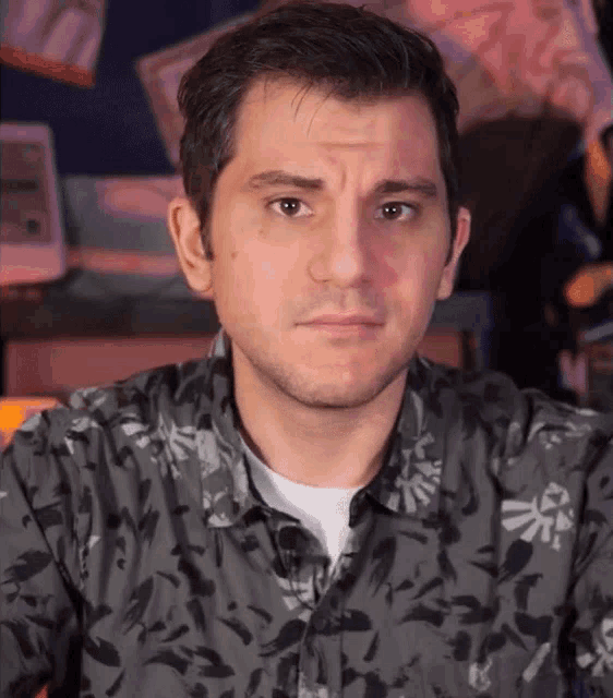 a man wearing a black shirt with a zelda logo on it