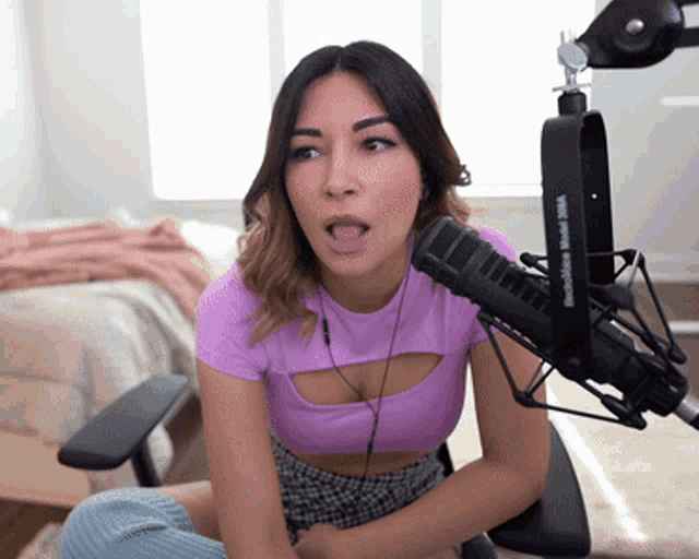 a woman in a purple shirt is sitting in front of a microphone that says ' bubbles model ' on it