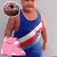 a young boy is holding a pink pig and a donut in his hand .