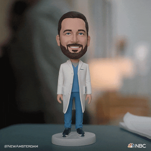 a bobble head of a man in a lab coat and scrubs with the hashtag #newamsterdam