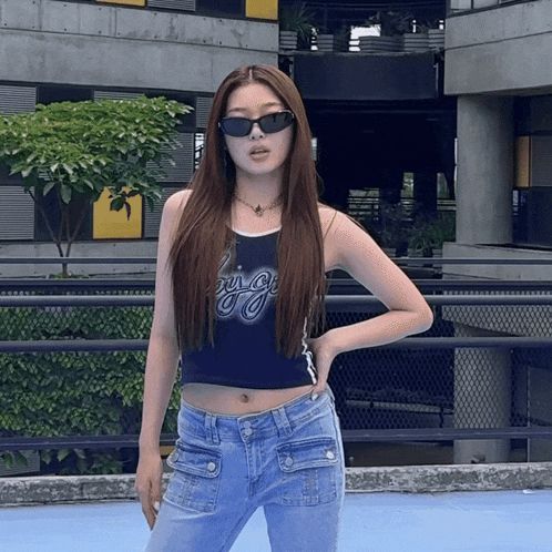 a woman wearing sunglasses and a crop top that says ' pretty girl '
