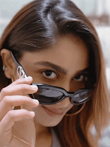 a woman wearing a pair of black sunglasses with the letter a on the lens