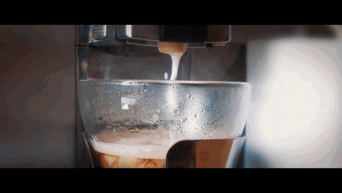 a close up of a coffee machine pouring milk into a cup