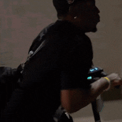 a man walking down a sidewalk with a duffel bag on his back