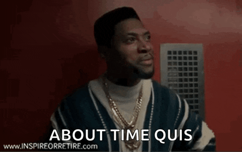a man in a striped sweater is standing in front of a red wall and says about time quis .