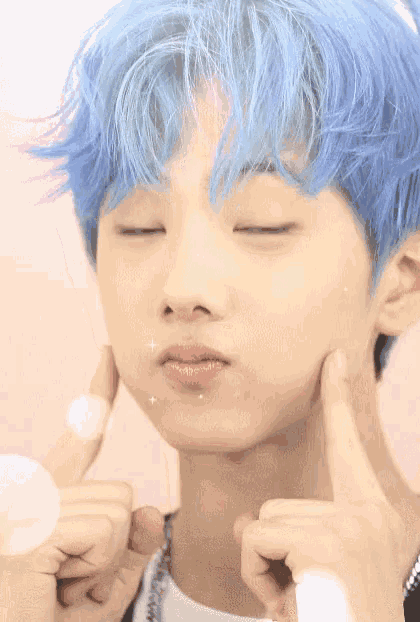 a young boy with blue hair is giving a thumbs up sign