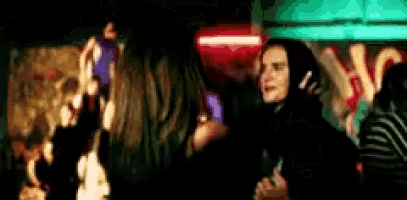 a blurry picture of a group of people dancing in a dark room .