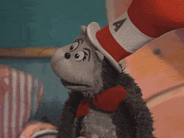 the cat in the hat is wearing a red and white hat with the letter a on it