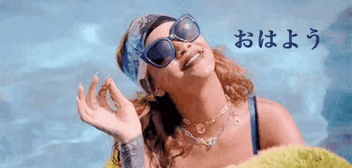 a woman wearing sunglasses and a headband is smiling and looking up .