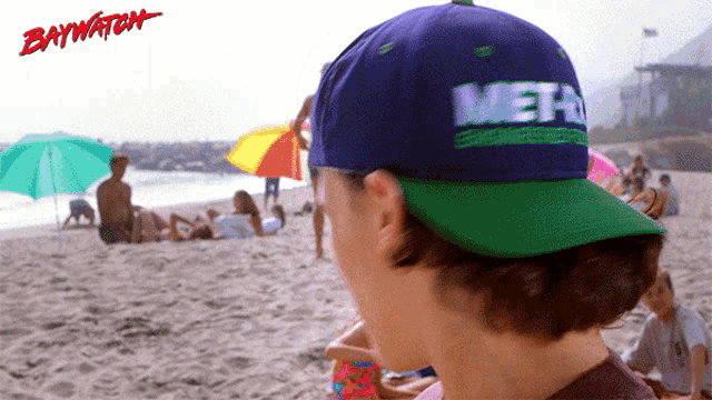 a person wearing a blue and green hat that says meth