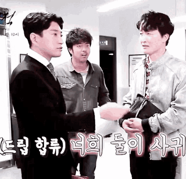 a man in a suit shakes hands with another man in a room with chinese writing on the wall