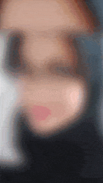a close up of a woman 's face with a blurred background