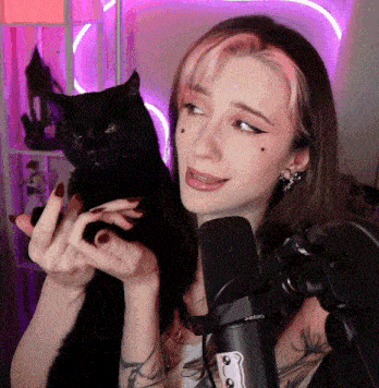 a woman holding a black cat in front of a microphone that says shure