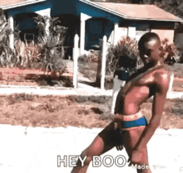 a man in a swimsuit is walking down the street and says hey boo