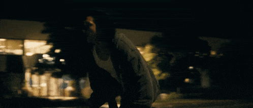 a blurry picture of a person in front of a building at night