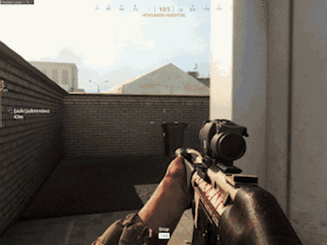 a person holding a rifle in front of a brick wall with the number 105 on the screen