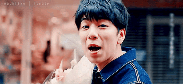 a young man in a blue shirt eating ice cream