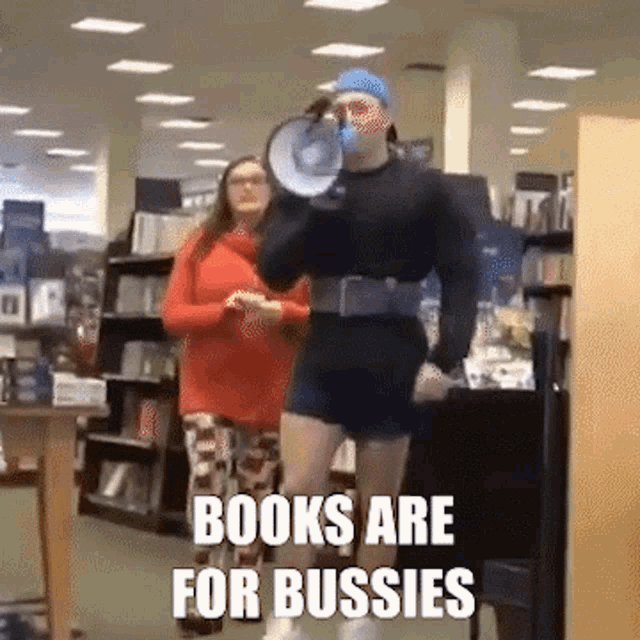 a man is holding a megaphone in a bookstore with the words books are for bussies