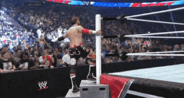 a man in a wrestling ring with a w logo