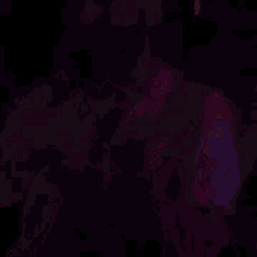 a man with a beard is standing in front of a purple light