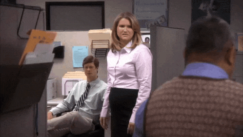 a woman in a pink shirt is standing next to a man in a blue shirt and tie