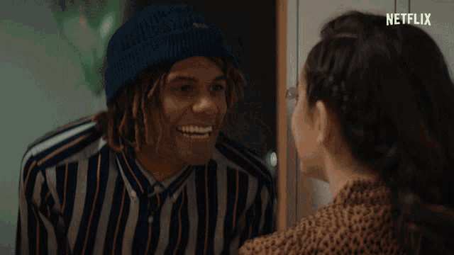 a man in a striped shirt is smiling next to a woman with netflix written in the corner