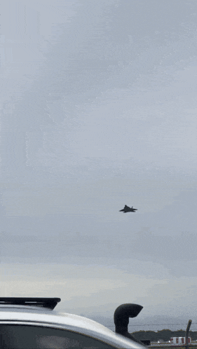 a plane is flying through a cloudy sky .