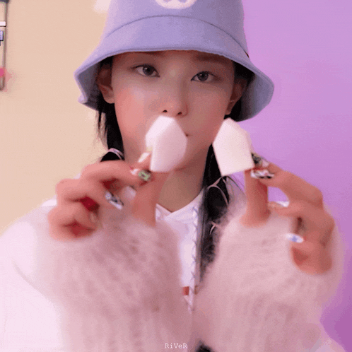 a woman wearing a blue hat is holding a white sponge