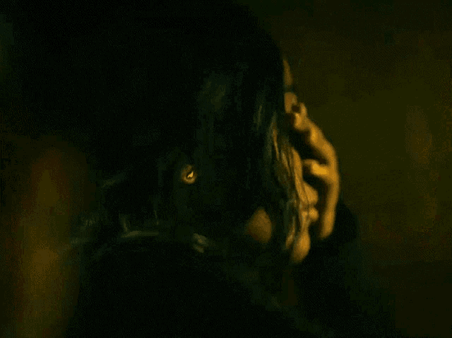 a close up of a woman 's face with her eyes closed in a dark room