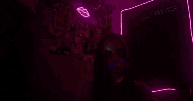 a woman smoking a cigarette in a dark room with neon lights