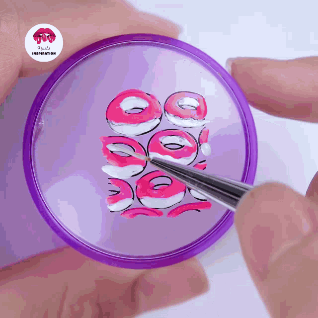 a person is painting donuts on a purple circle with a sticker that says rude inspiration