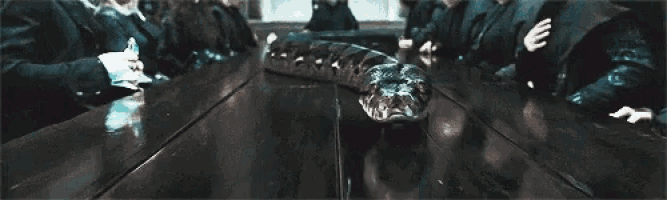 a close up of a person holding a wand in a dark room with smoke coming out of it .