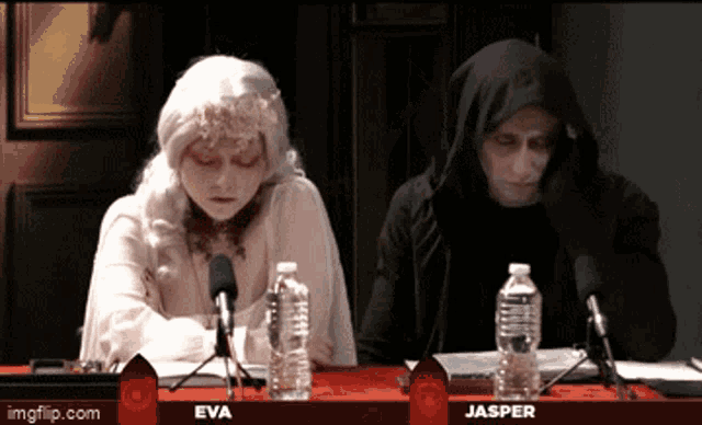 eva and jasper are sitting at a table with bottles of water